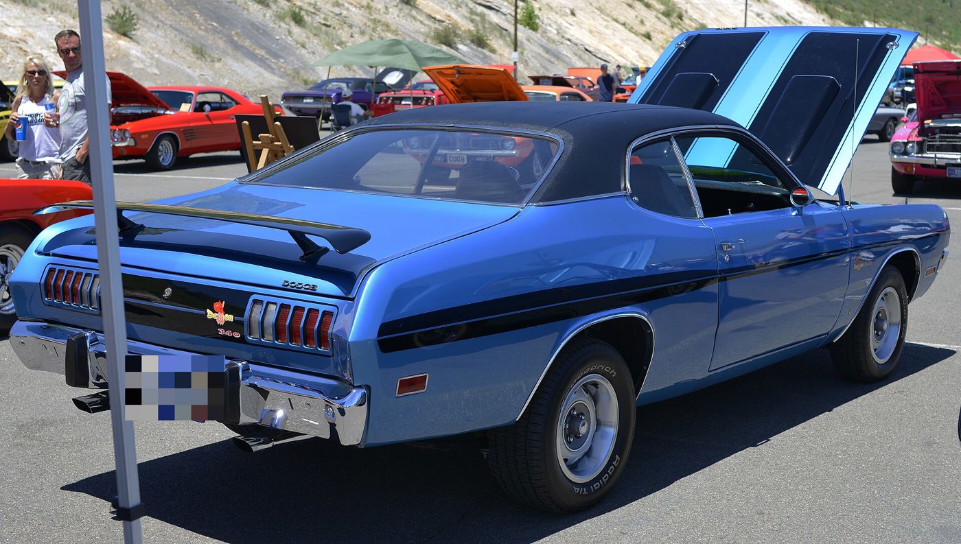 B5 Blue 1971 Dodge Demon with black roof, rear spoiler and side stripes, rear three-quarter at a car show