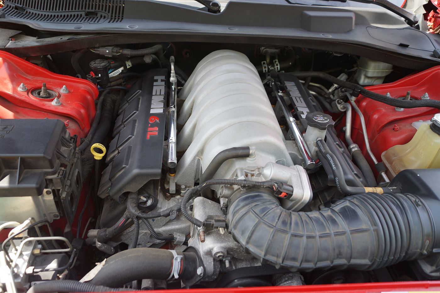 Engine bay of a red 2007 Dodge Magnum SRT8 showing the silver intake manifold and 6.1L Hemi lettering on the fuel-rail cover