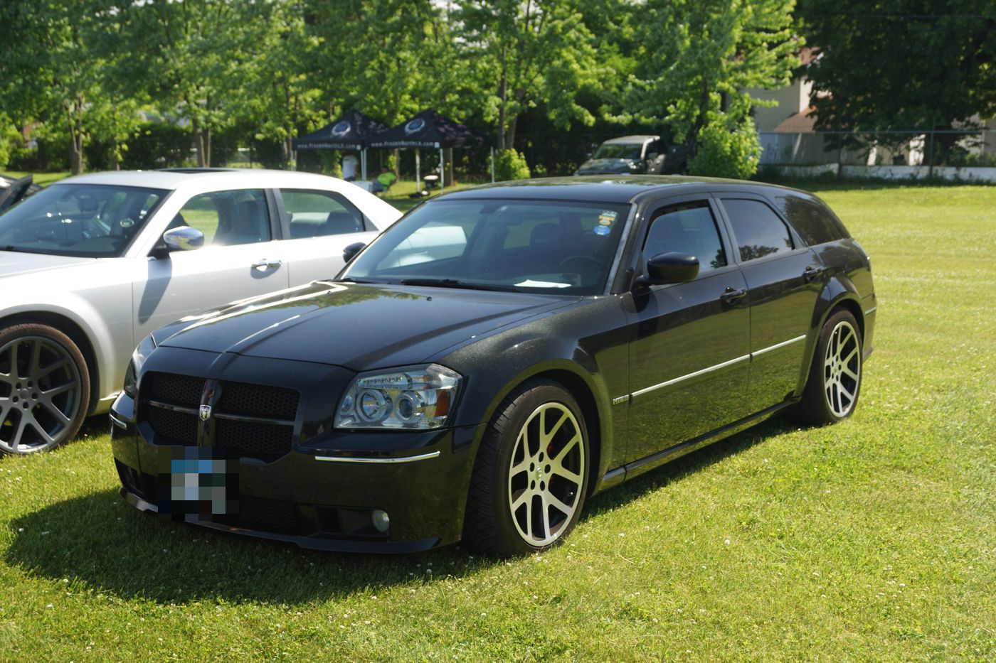 Black 2007 Dodge Magnum SRT8 wagon with the original crosshair grille and SRT five-spoke wheels, front three-quarter on grass