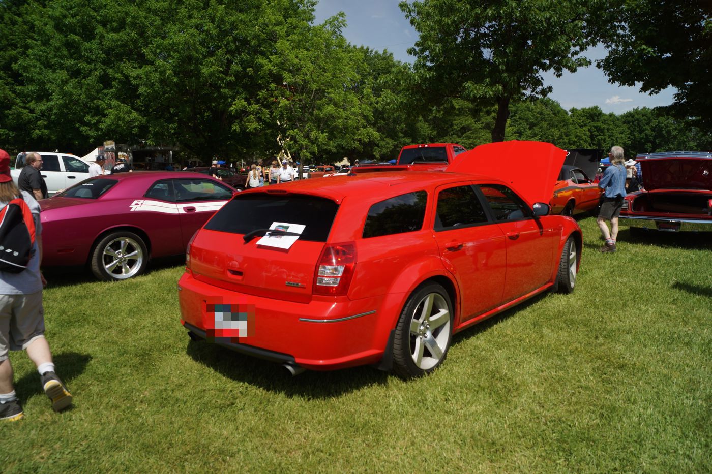 Red 2007 Dodge Magnum SRT8 wagon on grass at a car show, seen from the rear three-quarter with its chopped roofline