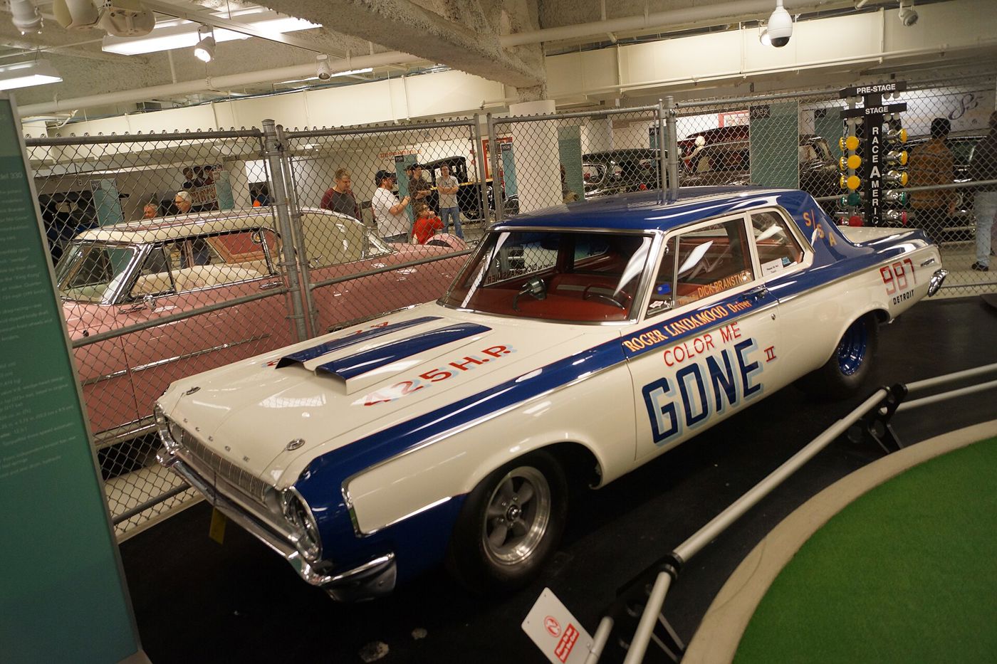 White and blue 1964 Dodge 330 drag car lettered COLOR ME GONE and 425 HP, shown in a museum