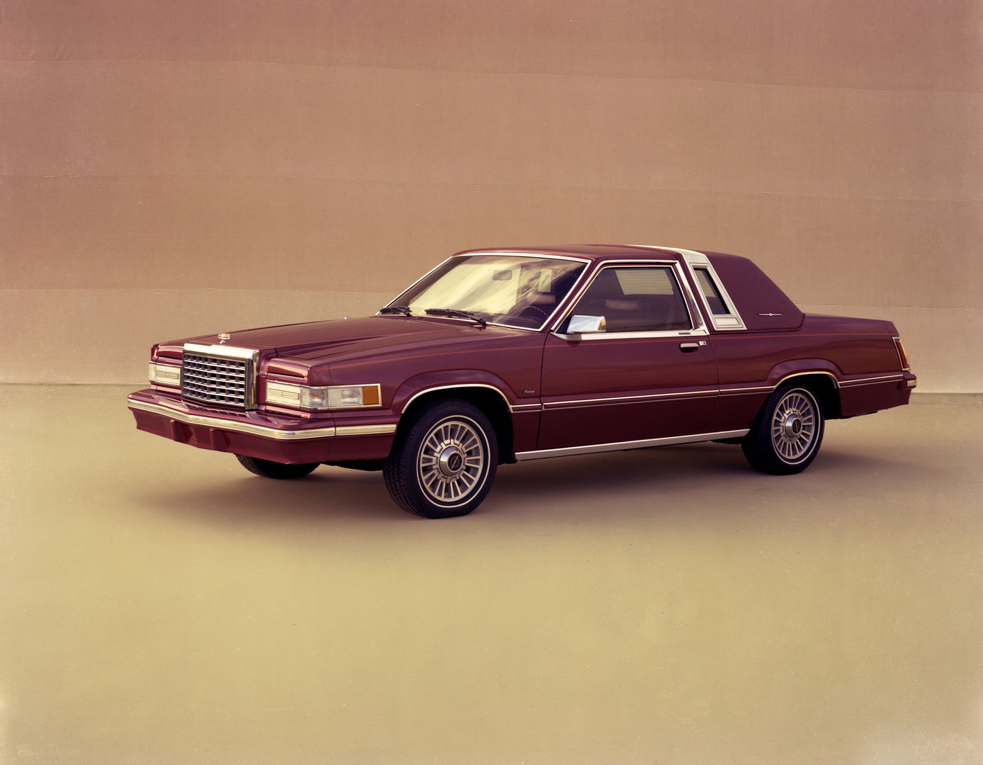 Maroon 1981 Ford Thunderbird coupe with a vinyl roof band, front three-quarter studio view