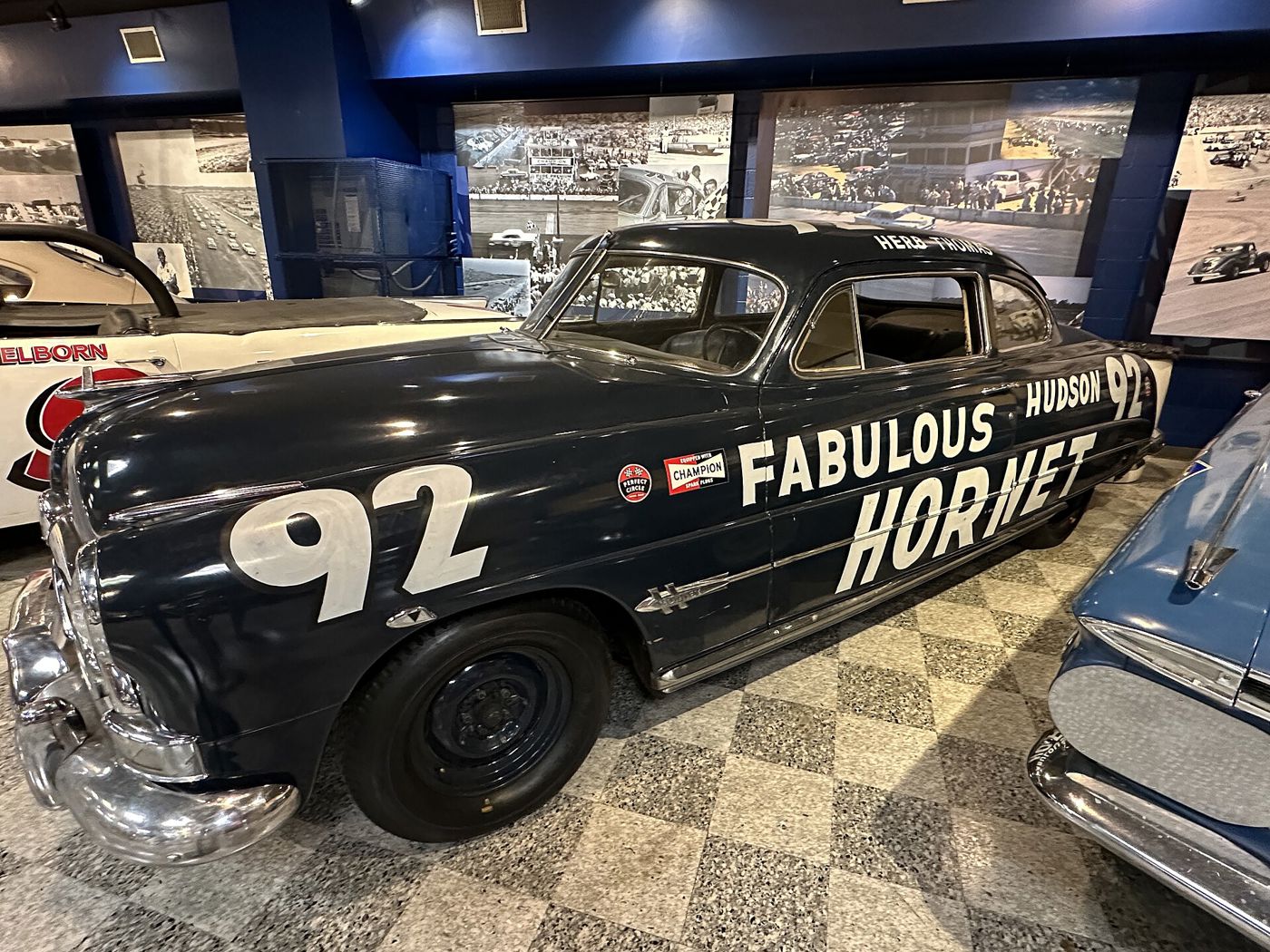 Dark blue Hudson Hornet stock car with number 92 and FABULOUS HUDSON HORNET lettering in a museum