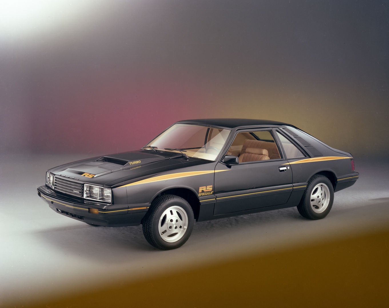 Black 1979 Mercury Capri RS Turbo hatchback with gold stripes, TURBO hood lettering and RS decals, front three-quarter studio view