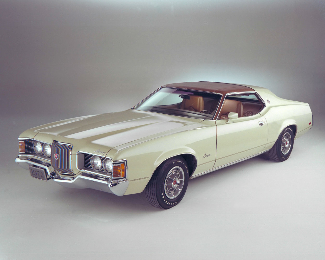 Pale green 1972 Mercury Cougar hardtop with a brown vinyl roof, front three-quarter studio view showing the exposed quad headlights
