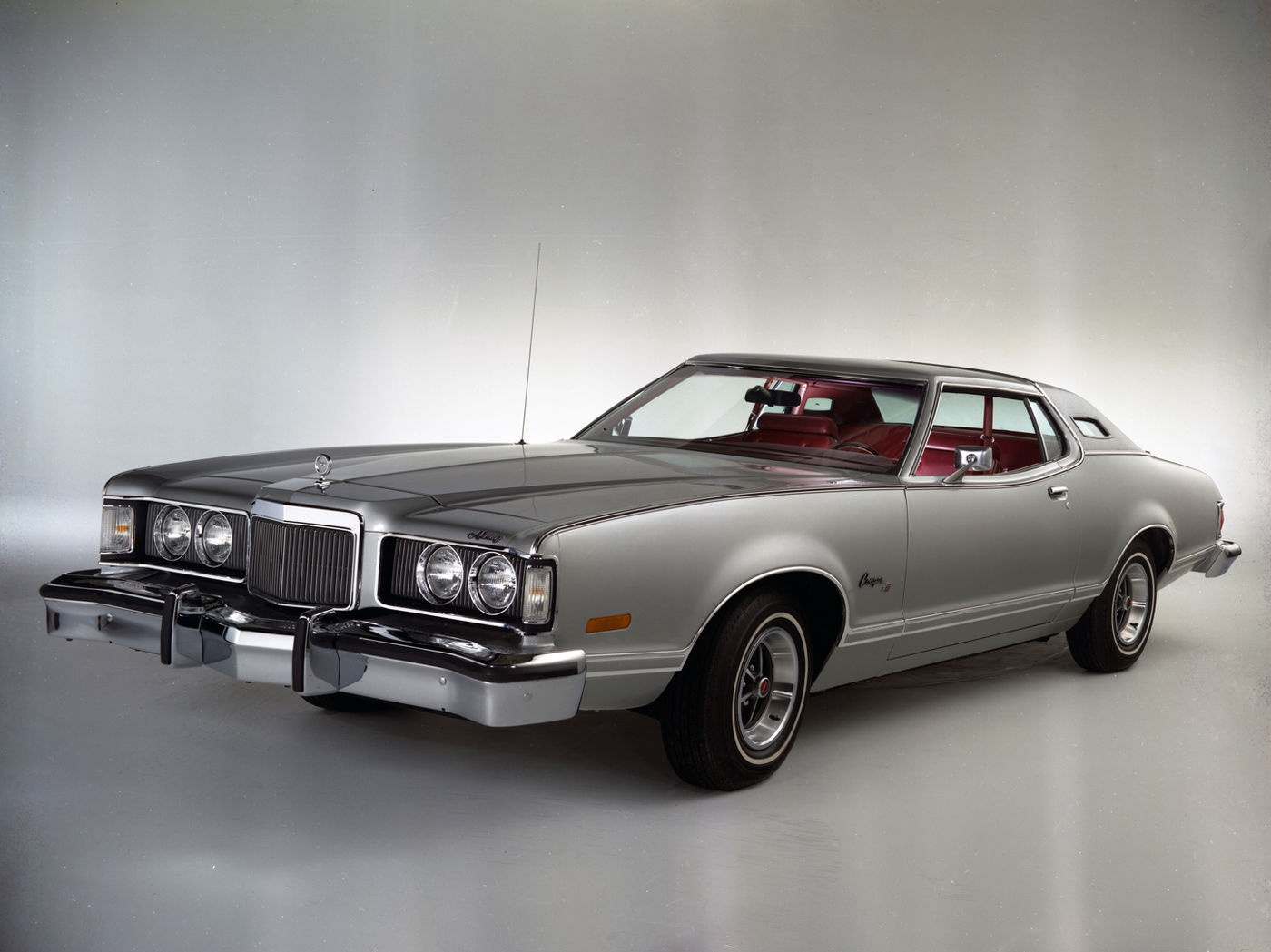 Silver 1974 Mercury Cougar XR-7 with a red interior and opera windows, front three-quarter studio view