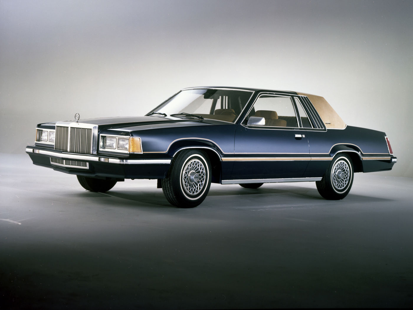 Dark blue 1980 Mercury Cougar XR-7 with a tan half-vinyl roof, front three-quarter studio view