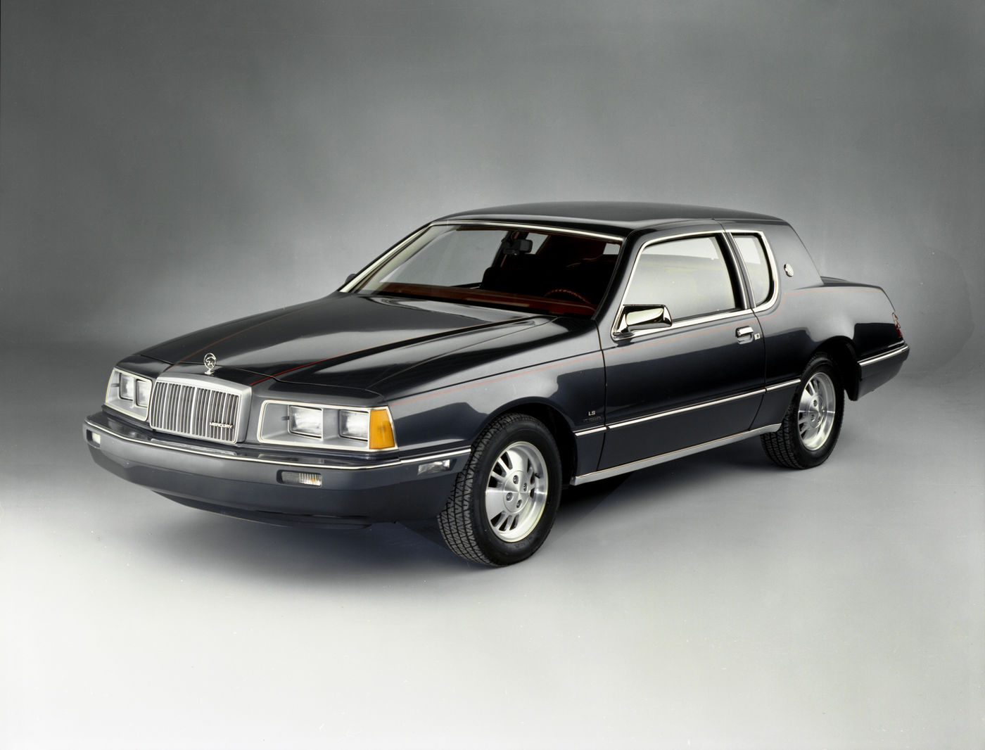 Black 1983 Mercury Cougar coupe with a notched rear roof pillar, front three-quarter studio view