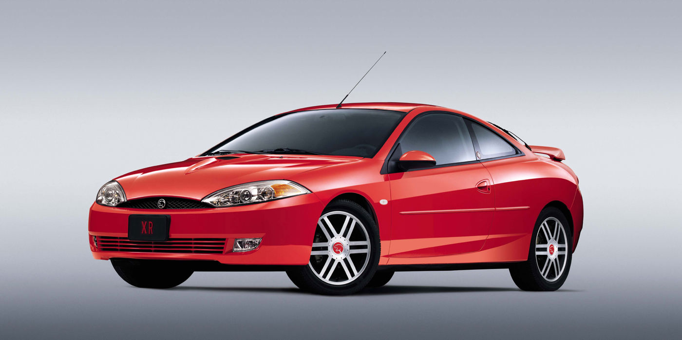 Red 2002 Mercury Cougar hatchback coupe with split-spoke wheels and an XR display plate, front three-quarter studio view
