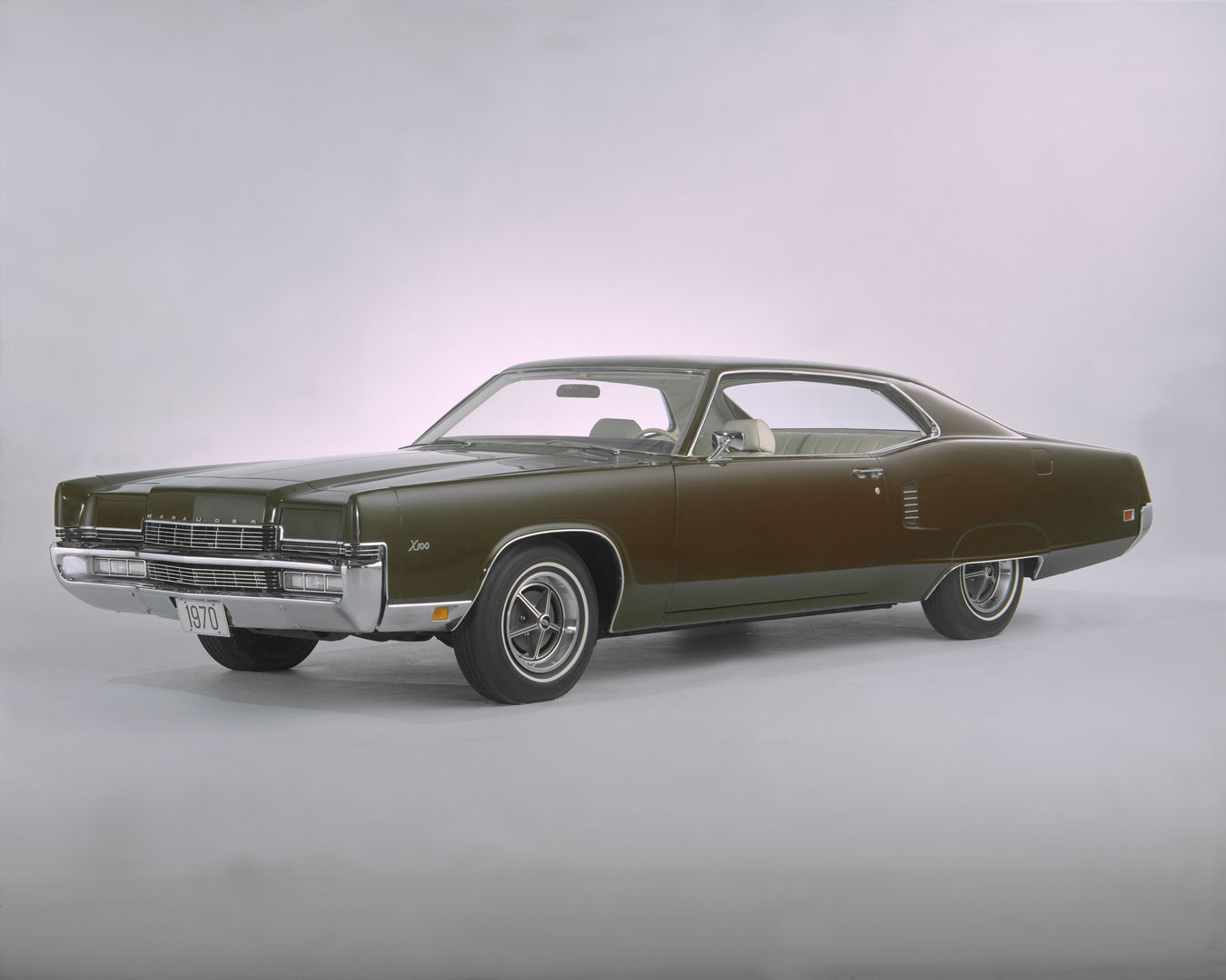 Dark green 1970 Mercury Marauder X-100 two-door hardtop with concealed headlights and styled wheels, front three-quarter studio view