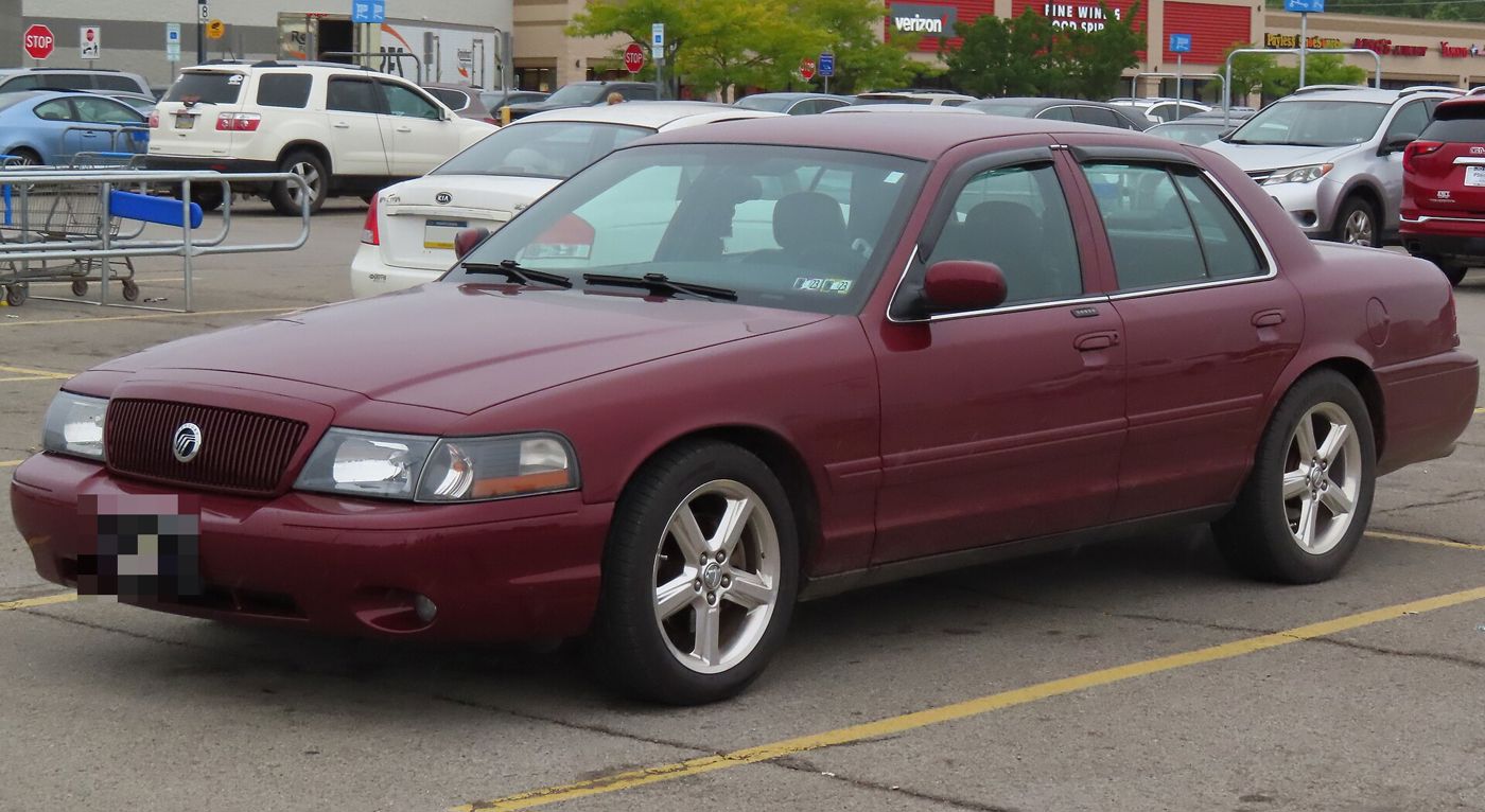 Dark red 2004 Mercury Marauder sedan in a store parking lot, front three-quarter view with the Marauder's five-spoke wheels