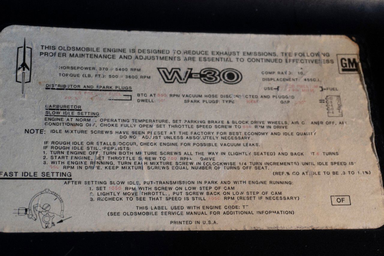 Worn Oldsmobile engine emissions and tune-up label with a large W-30 logo