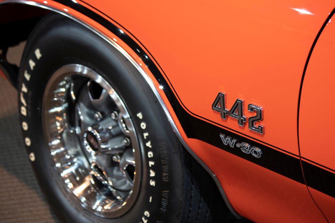 Orange front fender of a 1970 4-4-2 with 442 and W-30 badges and a Goodyear Polyglas tire