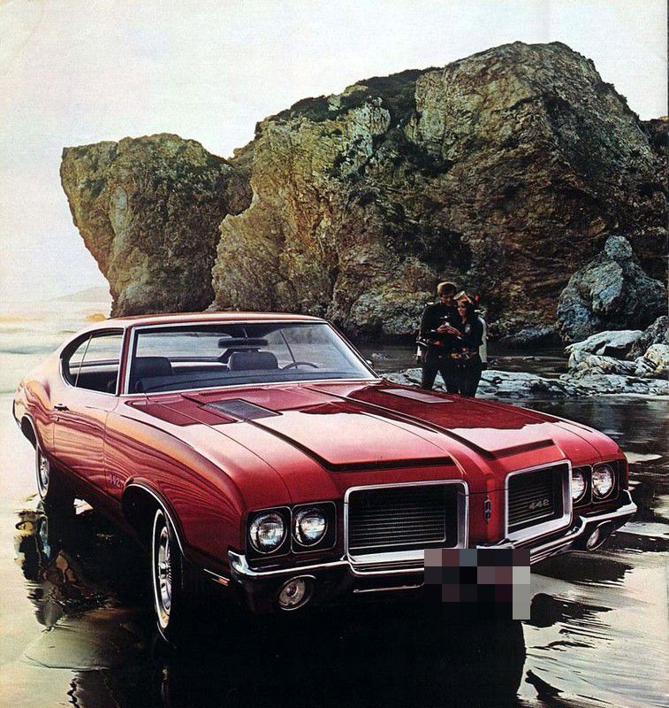 Brochure page: red 1972 Cutlass hardtop with 4-4-2 grille and fender badges and striped hood, on a rocky beach