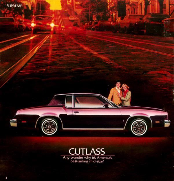 Brochure page: maroon-and-black 1980 Cutlass Supreme coupe in side view on a street at sunset, with a couple