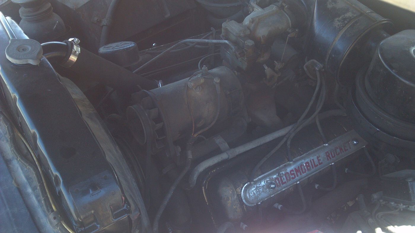 Engine bay of a 1949 Oldsmobile with the Oldsmobile Rocket valve cover visible