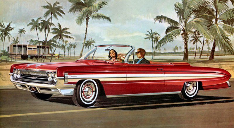 Brochure illustration: red 1961 Starfire convertible with a couple, front three-quarter, among palm trees