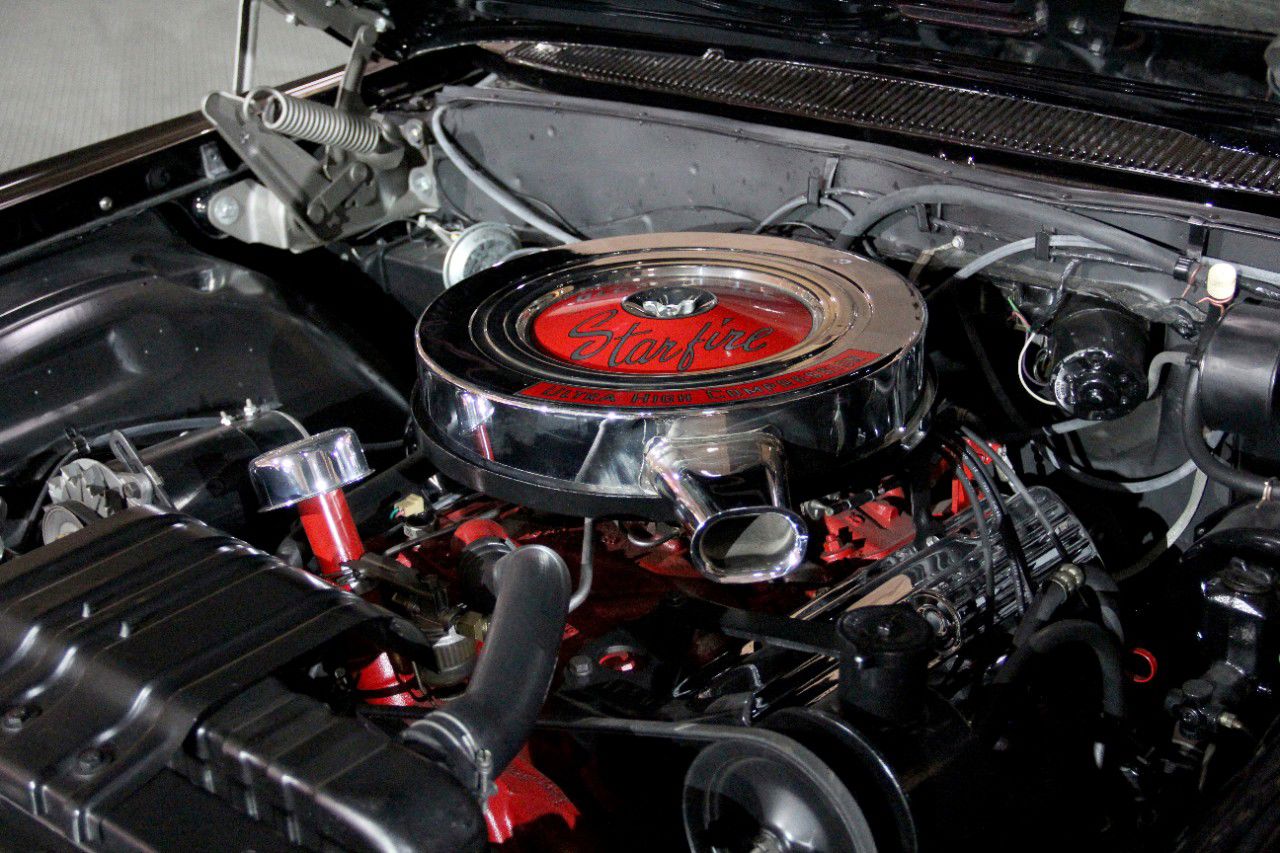 Engine bay of a 1962 Starfire with a chrome air cleaner bearing a red Starfire decal