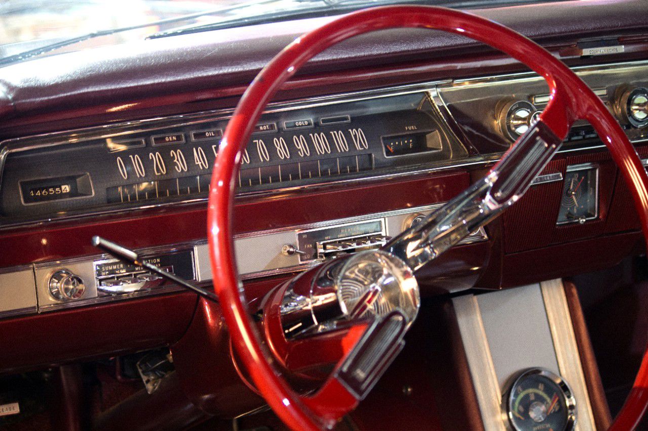 Red steering wheel, horizontal speedometer and console of a 1962 Oldsmobile Starfire