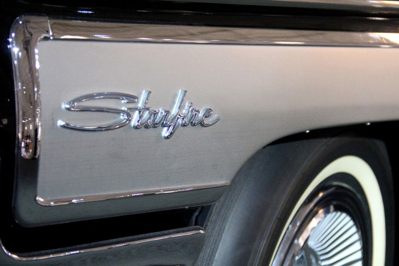 Close-up of the chrome Starfire script on the brushed-aluminum rear side panel of a 1962 Starfire