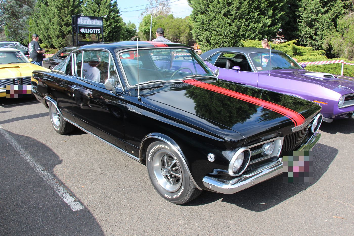Black 1965 Plymouth Barracuda Formula S with a red hood stripe and Formula S wheel medallions, front three-quarter