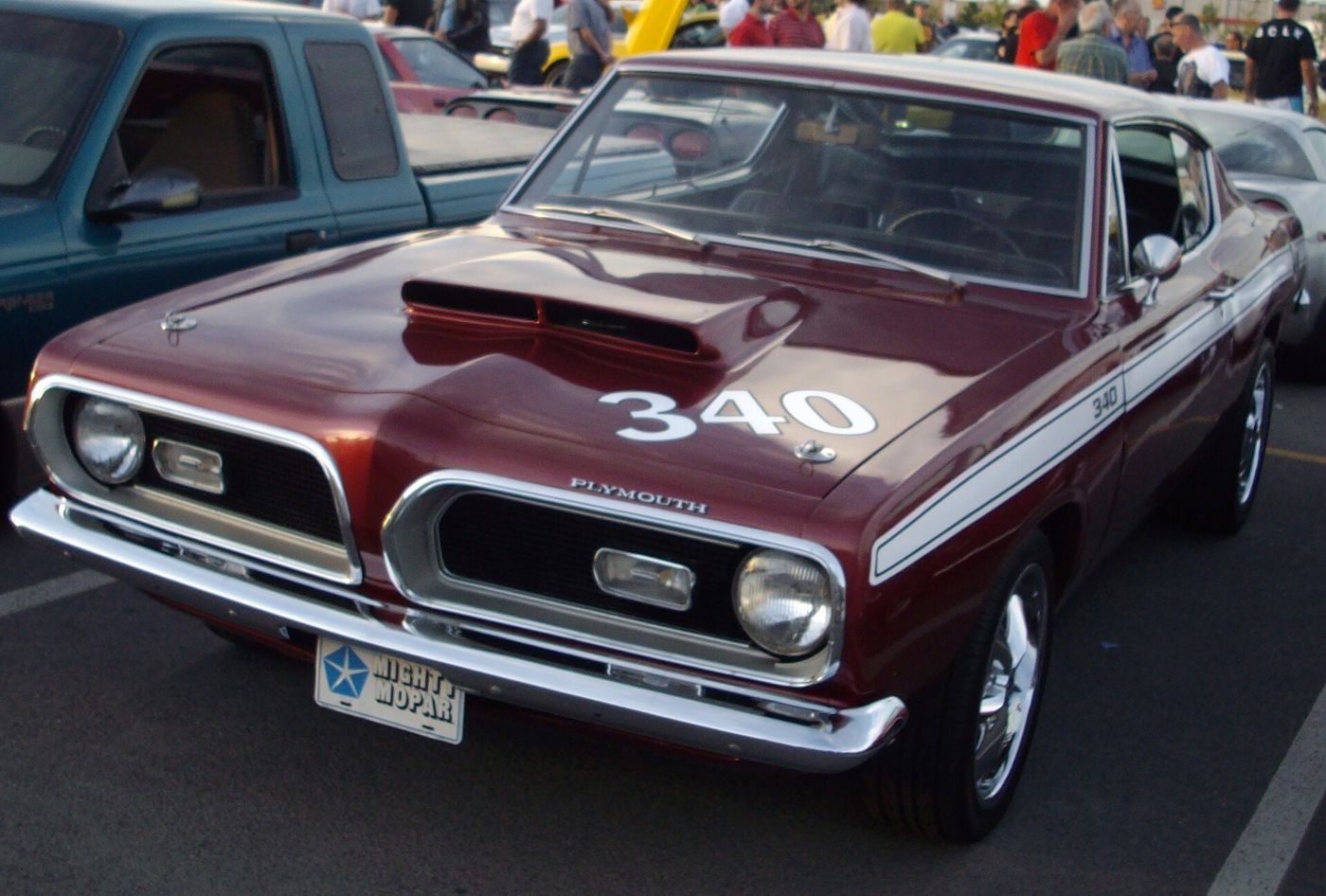 Maroon 1969 Plymouth Barracuda with a large white 340 on the hood and a hood scoop, front three-quarter