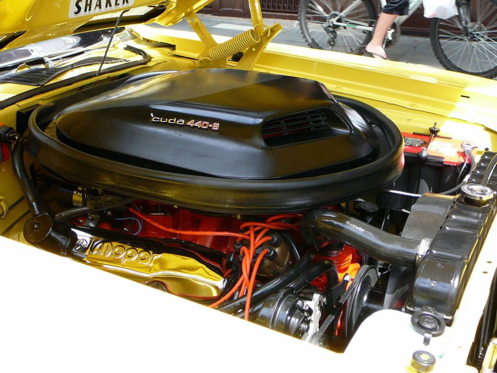 Engine bay of a yellow 1971 Plymouth Cuda with the black Shaker air cleaner lettered cuda 440-6