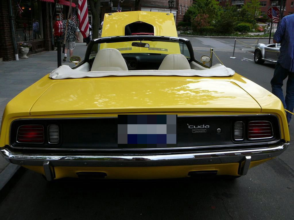 Rear of a yellow 1971 Plymouth Cuda convertible with top down, showing the 1971 tail panel and cuda script