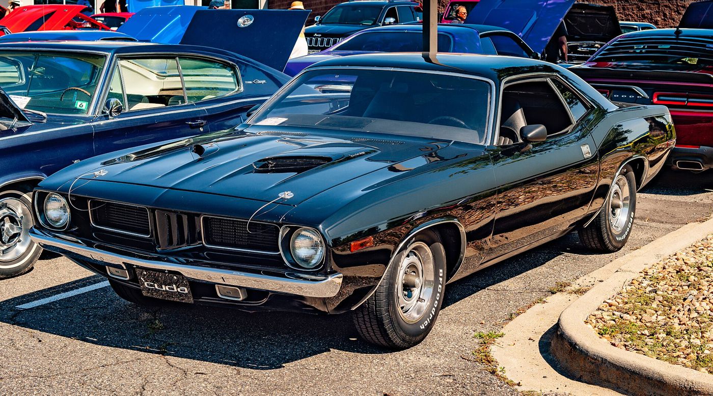 Black 1972 Plymouth Cuda with round single headlamps, twin hood scoops and a cuda front plate