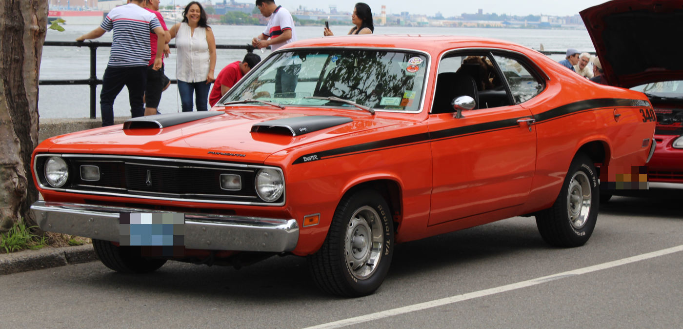 Orange 1971 Plymouth Duster 340 with a black hood treatment, twin hood scoops and black side stripe