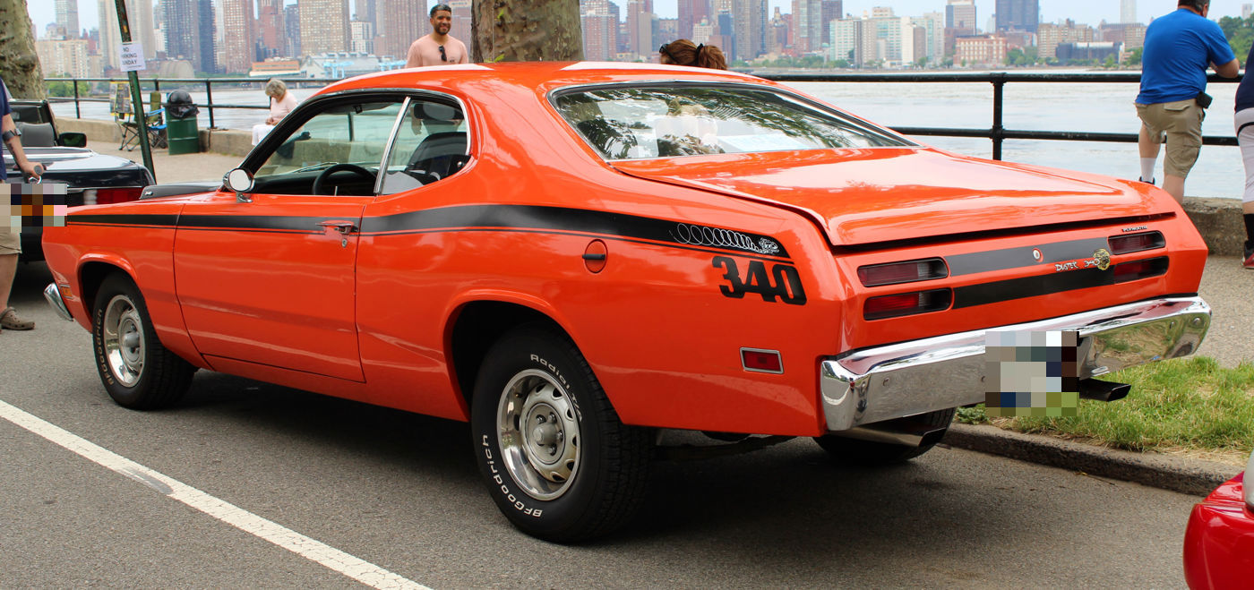 Orange 1971 Plymouth Duster 340 from the rear three-quarter showing the black stripe ending in a big 340 on the quarter panel