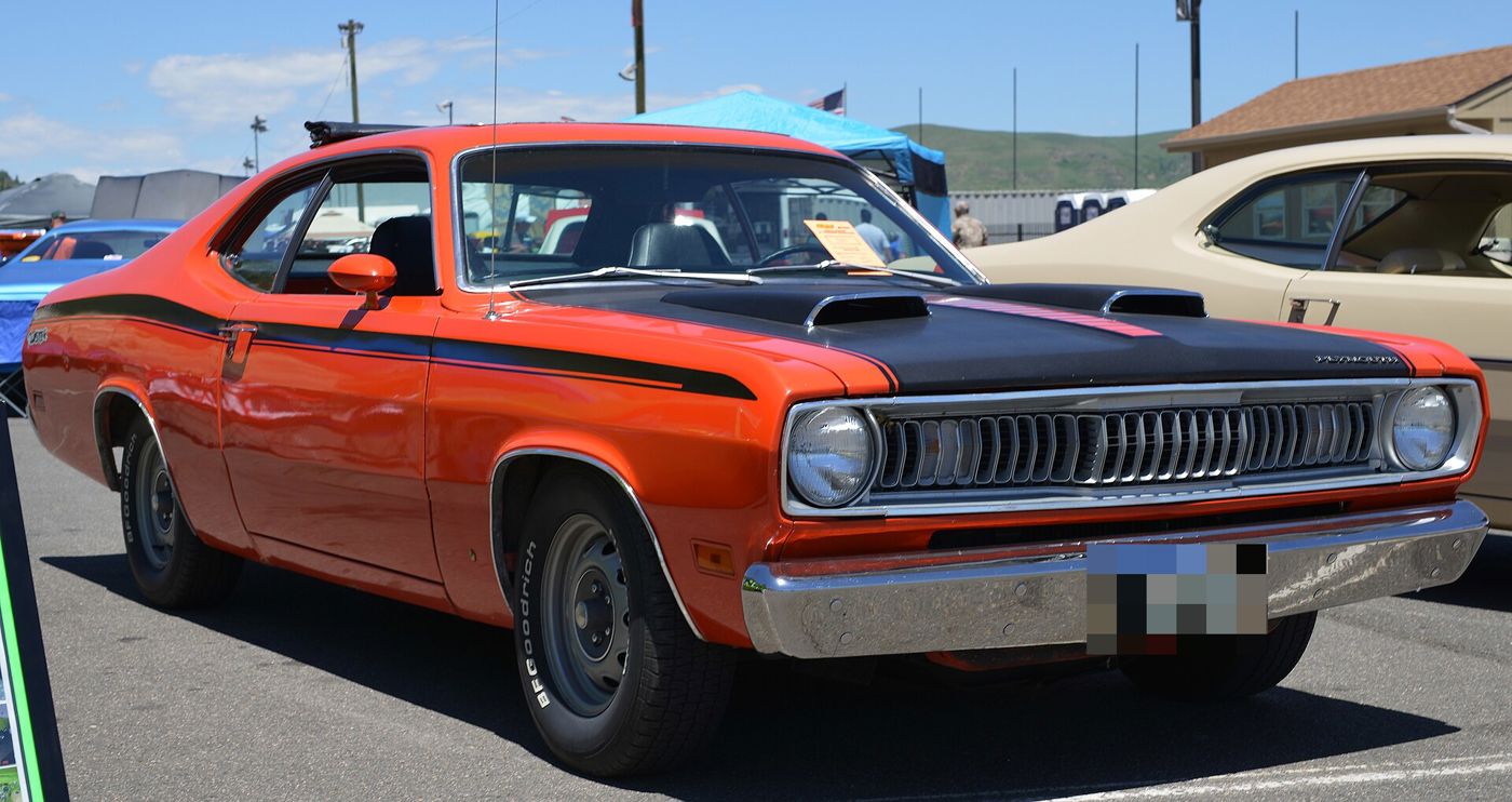 Orange 1971 Plymouth Duster Twister with a black hood, hood scoops and black side stripe, front three-quarter