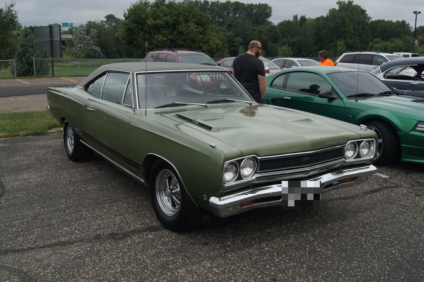 Green 1968 Plymouth GTX hardtop in a parking lot, front three-quarter