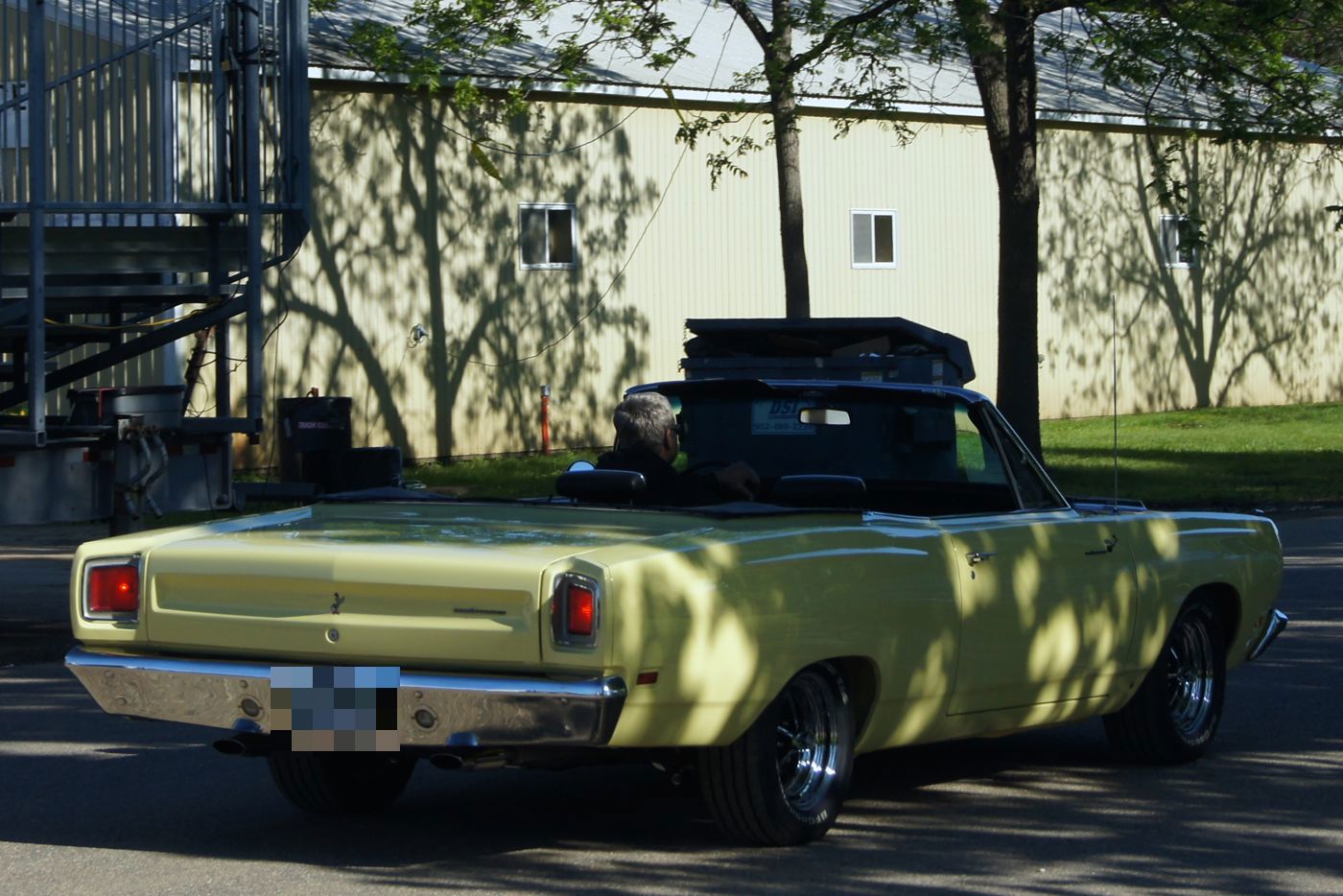 Yellow 1969 Plymouth Road Runner convertible, top down, from the rear three-quarter