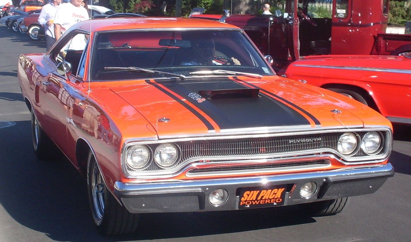 Orange 1970 Plymouth Road Runner seen close from the front, showing the 1970 loop grille and black-striped hood