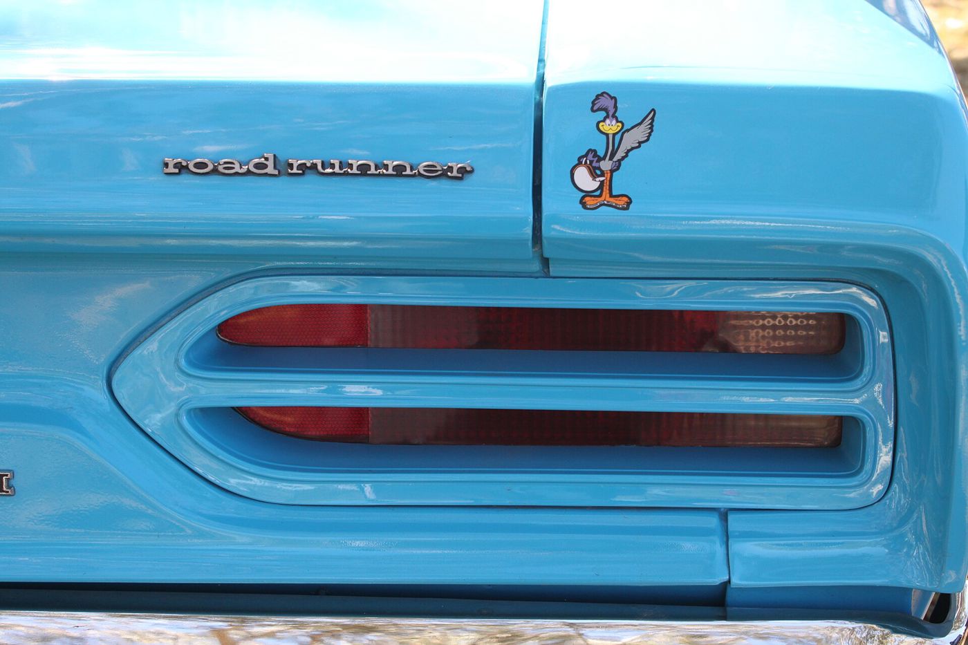 Close-up of the road runner script, the cartoon Road Runner emblem and the twin-slot 1970 taillamp on a blue Superbird
