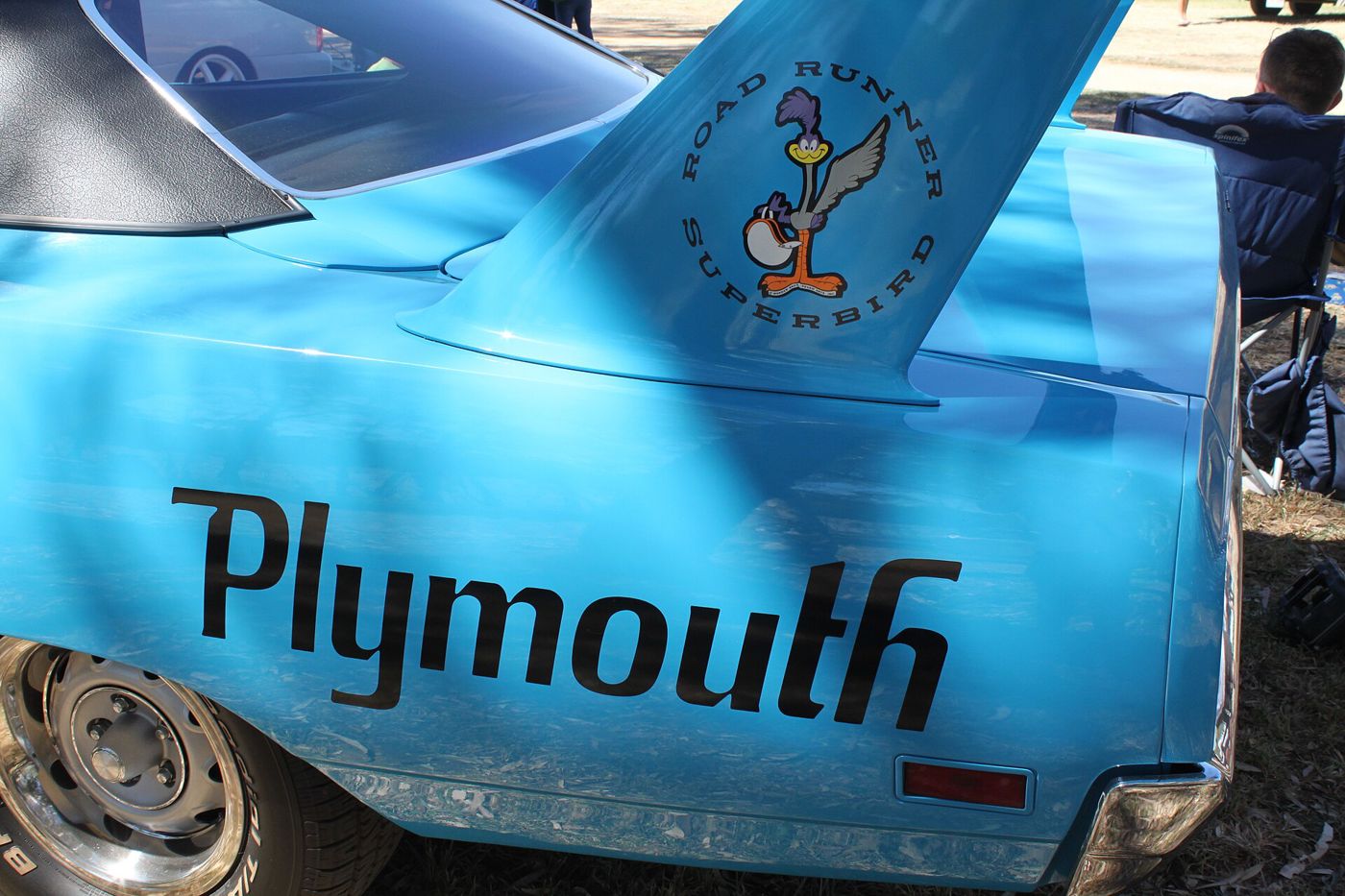 Close view of a blue 1970 Plymouth Superbird wing upright with the Road Runner Superbird emblem, above large Plymouth lettering