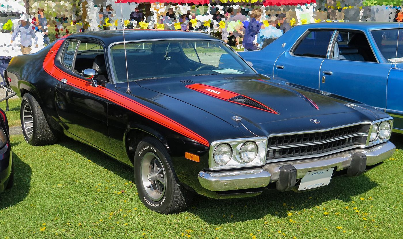 Black 1973 Plymouth Road Runner with red side and hood stripes and 400 lettering on the hood, front three-quarter