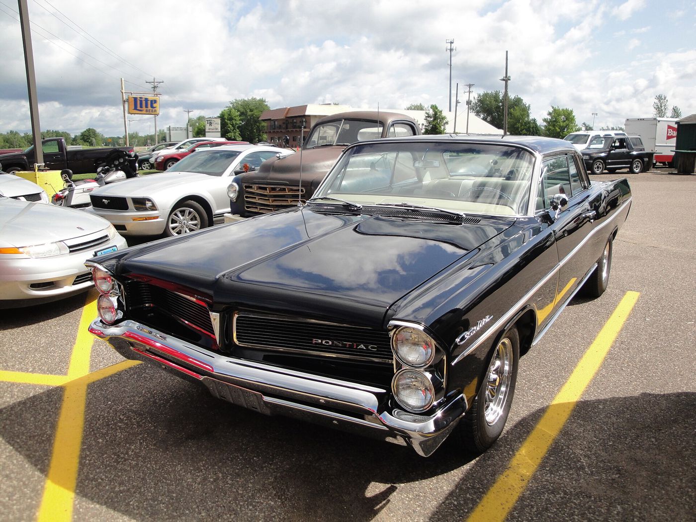 Black 1963 Catalina two-door hardtop with stacked headlights and split grille, seen from the front three-quarter in a parking lot