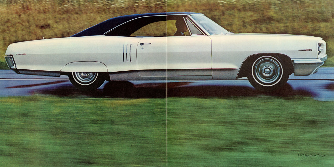White 1966 Pontiac 2+2 hardtop with a dark roof and louvered front fenders, in full side view at speed on a road