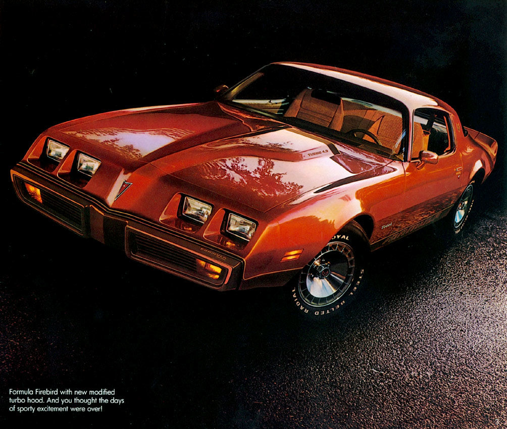 Orange-red 1980 Formula Firebird with an offset hood bulge, front three-quarter on a dark wet road