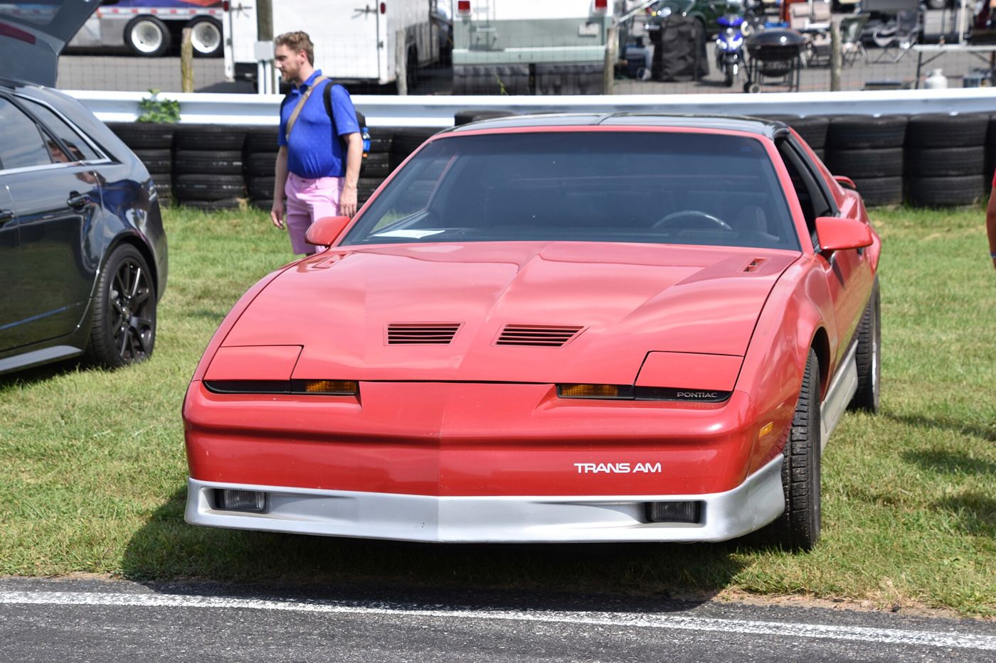 Red 1985 Trans Am with hood louvres, fog-lamp front fascia and TRANS AM lettering, front three-quarter on grass at Lime Rock Park