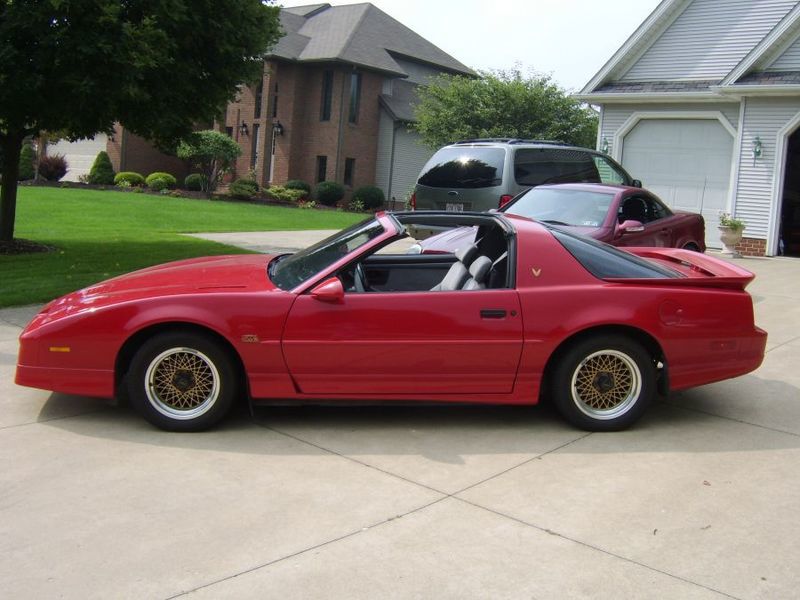 Red 1988 Trans Am GTA with gold diamond-spoke wheels and T-tops removed, side view on a driveway