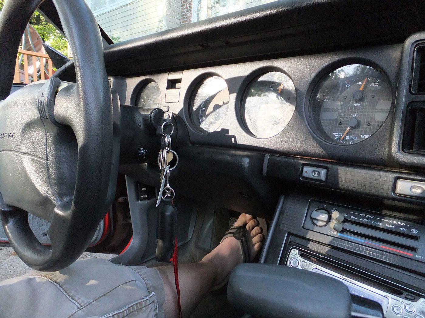 Driver's view of a 1991 Firebird dash with airbag steering wheel, four round gauges and center console