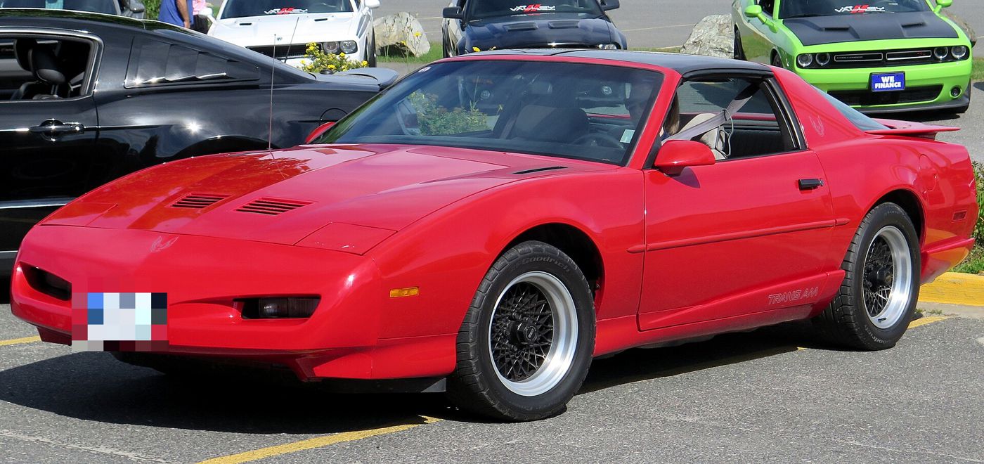 Red 1991 Trans Am with the new slimmer nose and hood louvres, front three-quarter in a parking lot