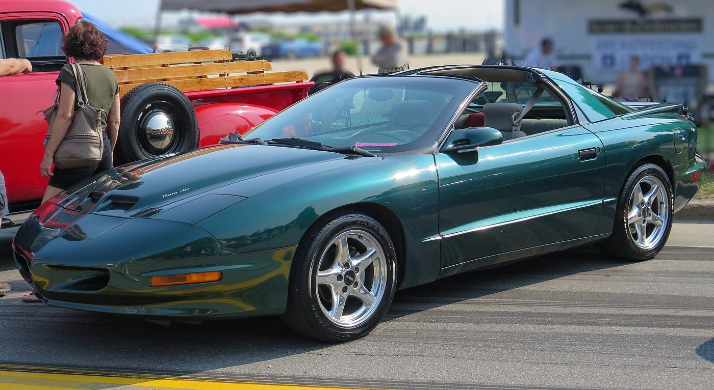 Dark green 1997 Firebird Formula with a T-top and five-spoke wheels, front three-quarter at a car show