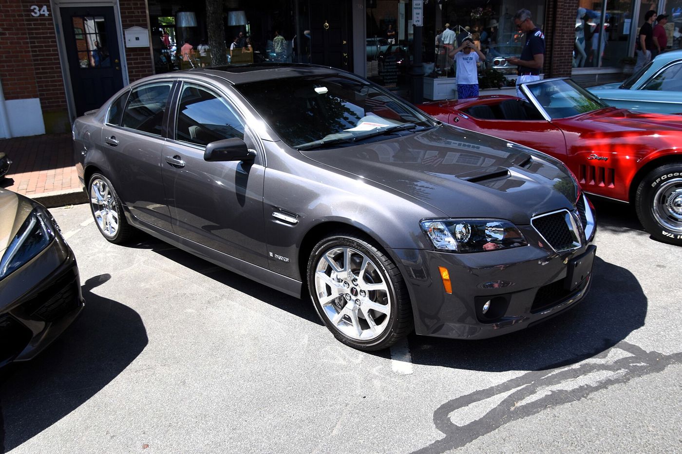 Gray 2009 Pontiac G8 GXP sedan with hood vents, split grille and GXP lower fascia, seen from the front three-quarter at a street car show