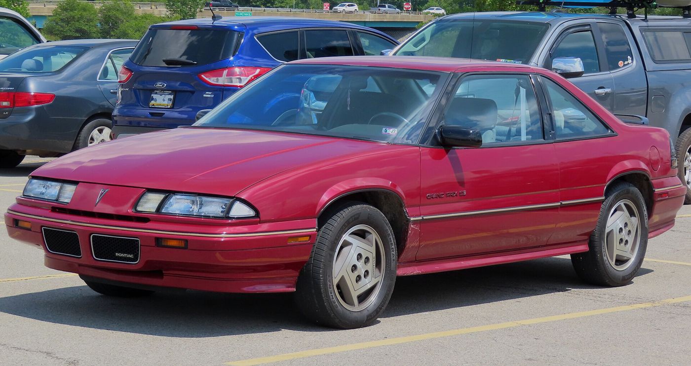 Red 1989 Grand Prix SE coupe of the front-drive W-body generation, front three-quarter in a parking lot