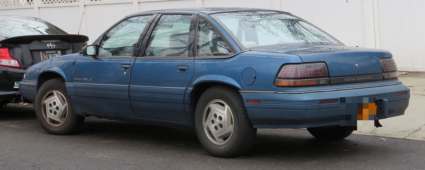 Blue 1993 Grand Prix LE sedan from the rear three-quarter, showing its wraparound taillamps