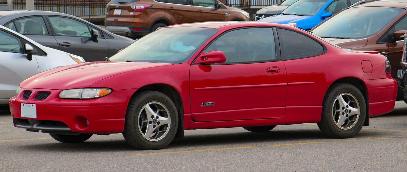 Red 2001 Grand Prix GTP coupe with GTP badge on the door, side-front view in a parking lot